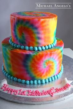 two tiered cake decorated with multi colored icing