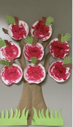 an apple tree made out of paper plates with handprints on the leaves and branches