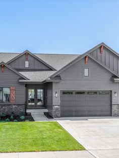 a large gray house sitting on top of a lush green field