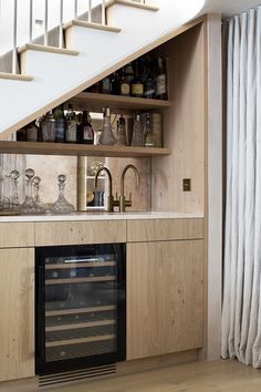 a kitchen with an oven, wine rack and stairs leading up to the upper floor