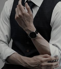 a man wearing a suit and tie holding his hands together