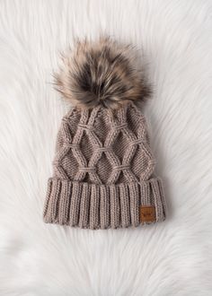 Taupe diamond cable knit pom hat Natural faux fur pom accent Fleece lined Crown patch on the left side One size 100% Acrylic Cable Knit Pattern, Knitted Hats Kids, Knit Hat For Men, Knit Jewelry, Cable Knit Hat, Dangle Necklaces, Pom Pom Hat, Blanket Gift, Gift Boutique