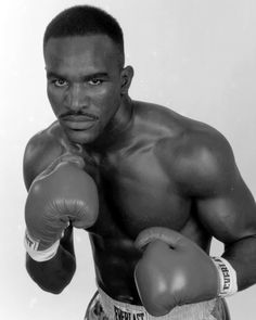 a black and white photo of a man wearing boxing gloves