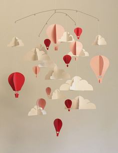 a mobile with hot air balloons hanging from it's sides in the shape of clouds