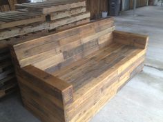 a wooden bench sitting next to stacks of lumber