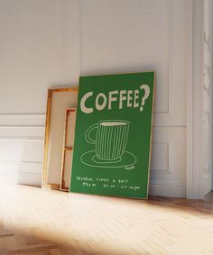 a coffee sign sitting on top of a hard wood floor next to a framed photo