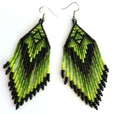 green and black seed beaded earrings on white background