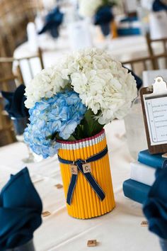 a vase filled with white and blue flowers on top of a table