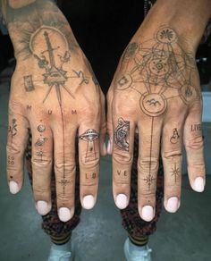 two hands with different tattoos on them, one has a compass and the other has an eye