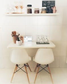 two white chairs sitting next to each other at a table