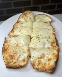 four pieces of bread covered in cheese on a white plate