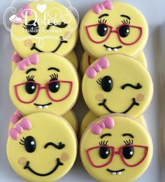 some yellow cupcakes with pink bows and glasses on them are decorated like smiley faces