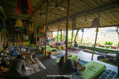 many people are sitting on the floor in a room with lots of blankets and rugs