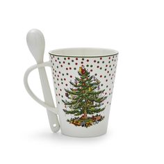 a cup with a spoon in it and a christmas tree design on the side,