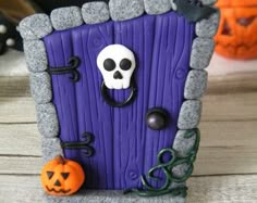 there is a purple door with a skull on it and two jack - o'- lanterns