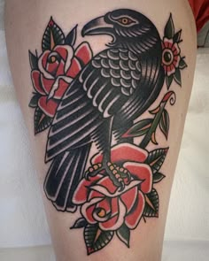 a black bird sitting on top of a red rose flower covered thigh with roses around it