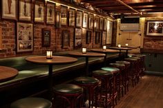 a row of bar stools sitting in front of a wall with pictures on it