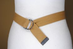 This Khaki d ring tie up belt has the following Measurements: end to end:  32''/80 cm width: 1.2"/3.8 cm Vintage condition. Should you have any questions don't hesitate to contact me.  Check out more awesome wares on our page https://www.etsy.com/shop/UWareiton With love,  UWareiton Military Belt, Purple Belt, Tan Leather Belt, Embellished Belt, Canvas Belt, Brown Tie, Beige Coat, Braided Belt, Western Belts