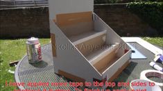 an open cardboard box sitting on top of a metal table next to cans and cups