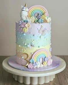 there is a cake decorated with rainbows and unicorns on the top of it