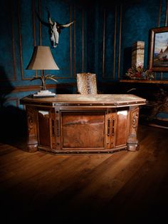 a table with a lamp on top of it in a room filled with paintings and furniture