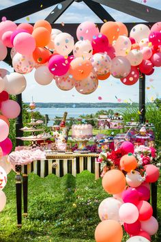 an outdoor party with balloons and confetti in the air, along with other decorations