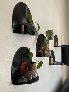 three black wall mounted shelves with plants and other items on them in the shape of hearts