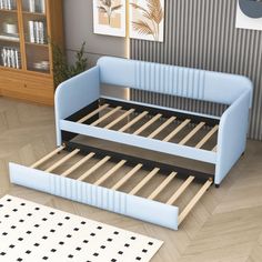 a blue bed frame sitting on top of a wooden floor next to a book shelf