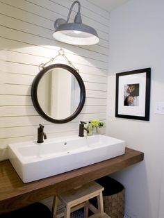 a bathroom with a sink, mirror and stool