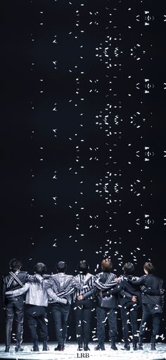 a group of men standing on top of a stage with confetti in the air