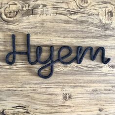 the word hysm spelled in felt on a wooden surface