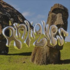 the word explore spelled out in metal letters on top of grass covered ground next to large rocks