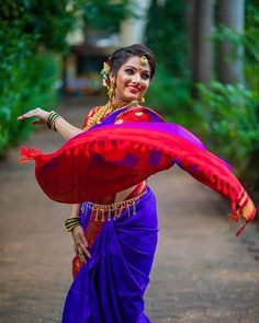 a woman in a purple and red sari dancing