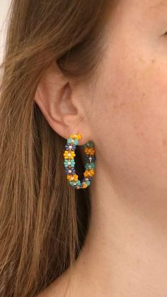 a close up of a person wearing some kind of earring with beads on it