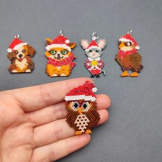 a hand holding a beaded christmas ornament with five different animals on it