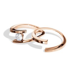 two rose gold rings with a single diamond on the top and one in the middle