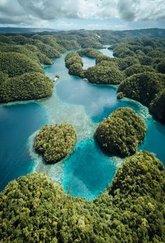 an aerial view of several small islands in the ocean surrounded by trees and blue water