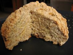 a piece of bread that has been cut in half on a black surface with one slice taken out