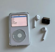 an ipod sitting next to ear buds and headphones