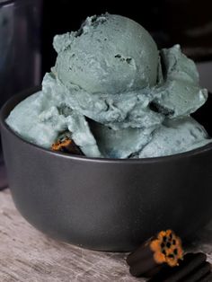 a bowl filled with ice cream next to a cookie