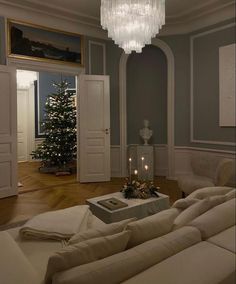 a living room filled with furniture and a chandelier hanging from it's ceiling