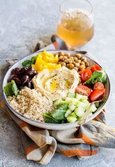 a salad with hummus, olives, tomatoes, cucumbers and other vegetables