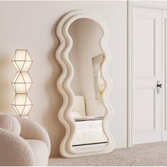 a large white mirror sitting on top of a wall next to a chair and ottoman