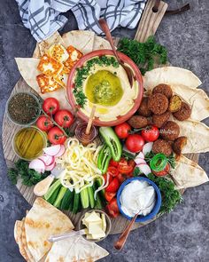 a platter filled with different types of food and dips on top of each other