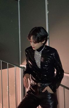 a woman in black leather pants and a shirt with sequins on the collar