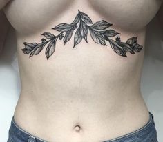 a woman's stomach with leaves tattoo on her side and the lower part of her body