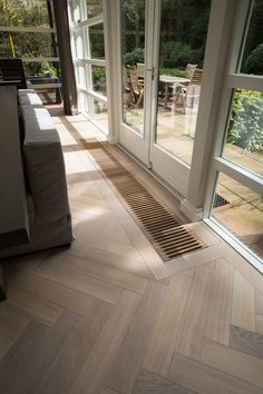 a living room with wood flooring and sliding glass doors