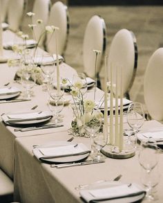 the table is set with white flowers and place settings for an elegant dinner or party