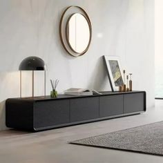 a living room with a large black entertainment center and round mirror on the wall above it