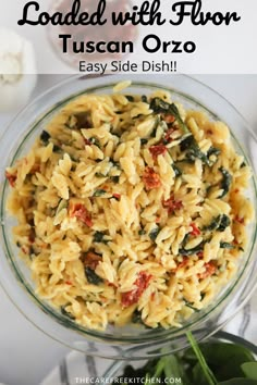 a bowl filled with pasta and spinach on top of a table